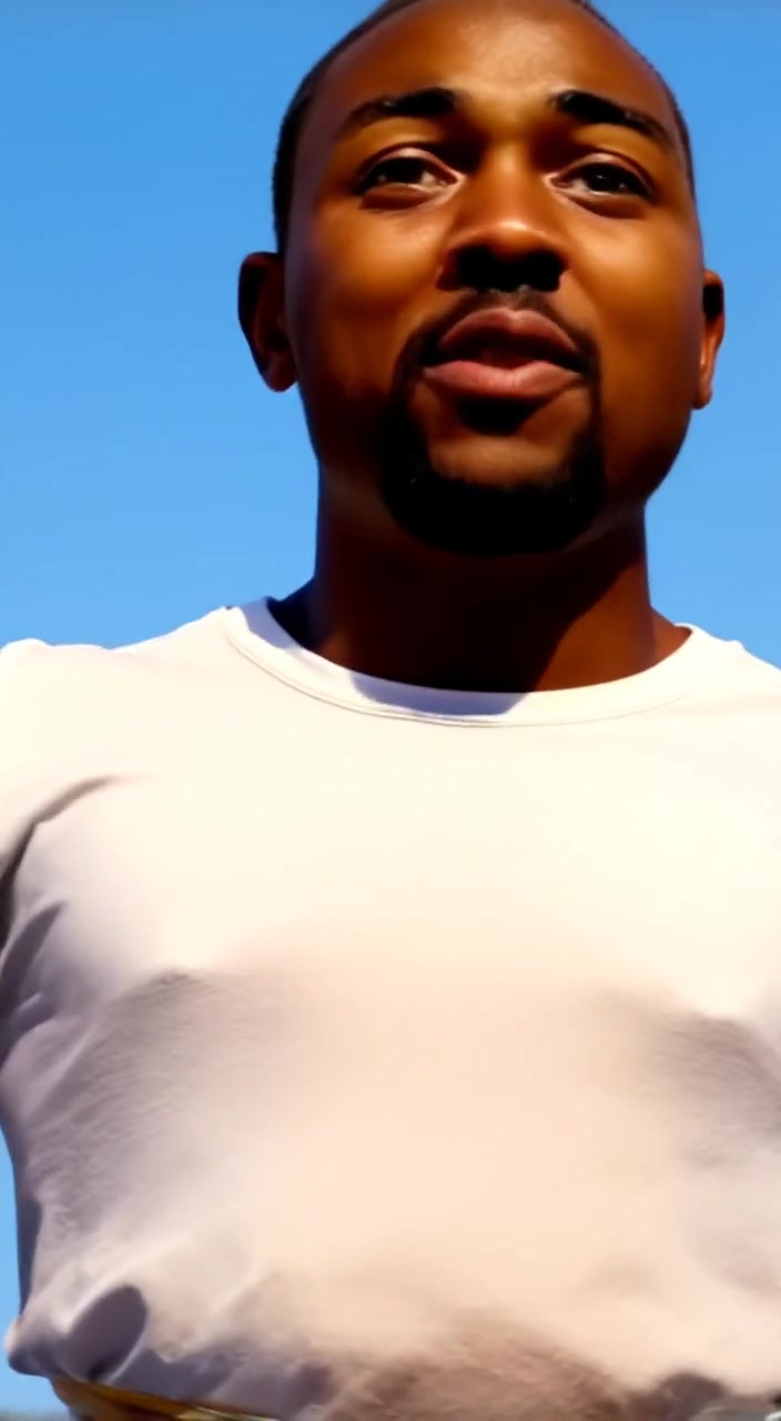 The man gestures passionately as he addresses the crowd under a clear blue sky in the open field.