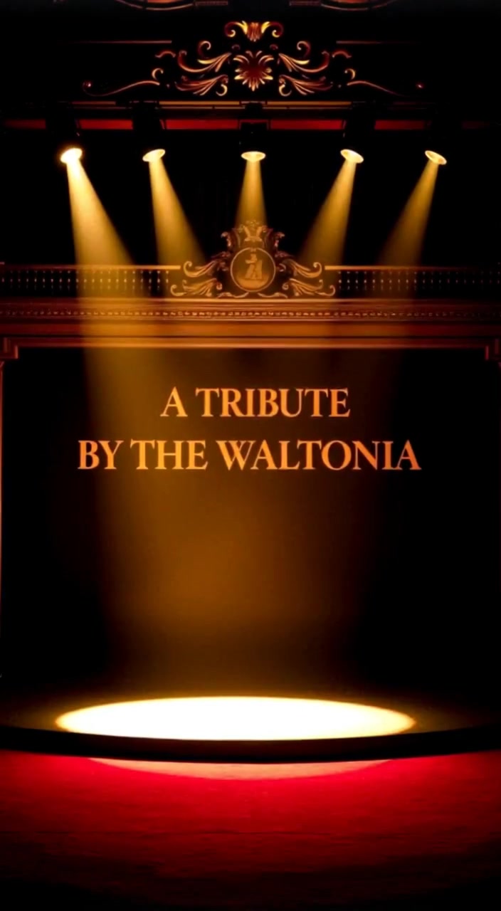 Gently, spotlights sweep across the grand stage, illuminating the ornate backdrop and the empty podium at center stage.