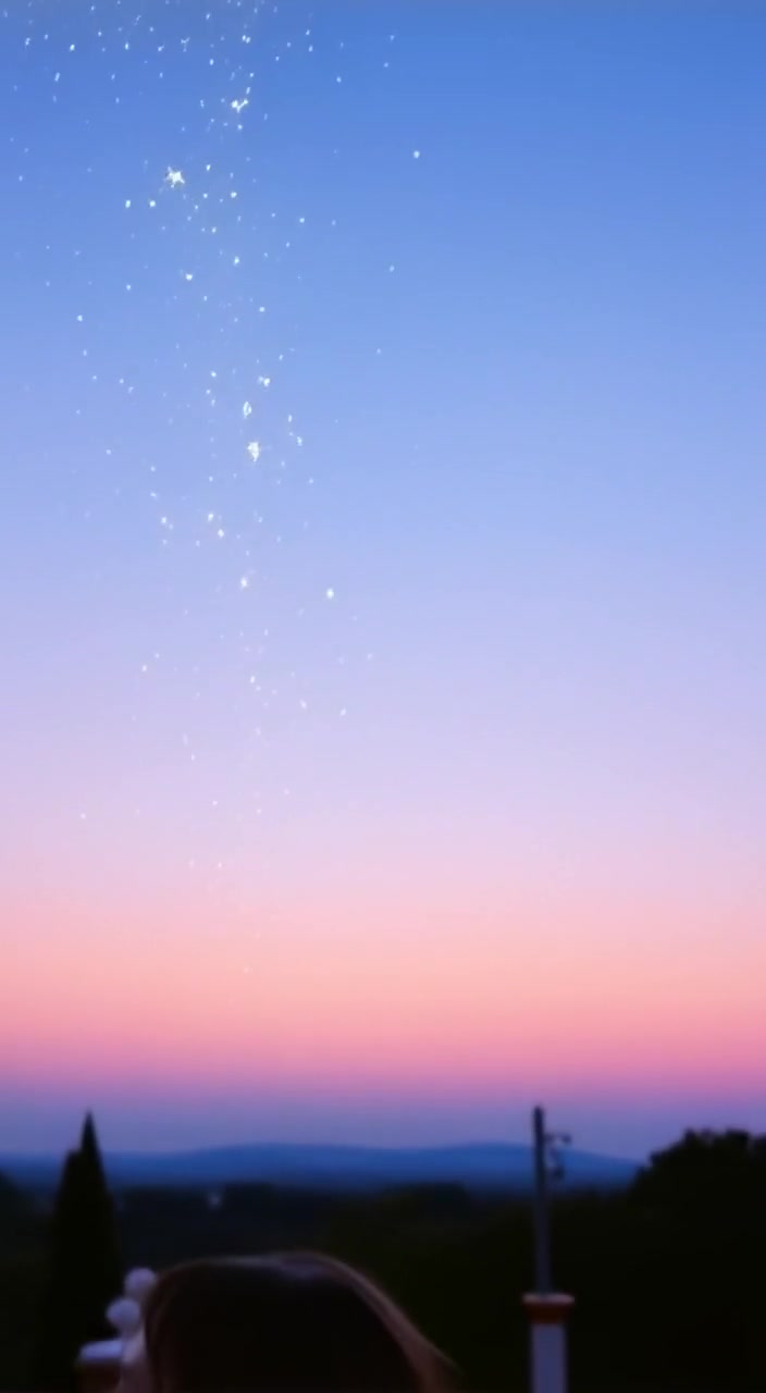 Stars gently fall from the night sky, illuminating a tranquil landscape below.