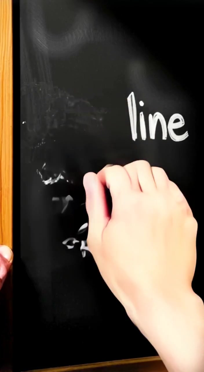 A hand gently erasing the chalkboard, leaving faint traces of the words behind.