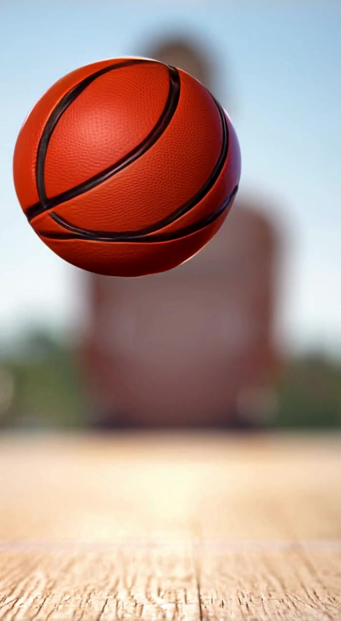 A basketball slowly rolls across the court, casting soft shadows as sunlight filters through the faded silhouette in the background.