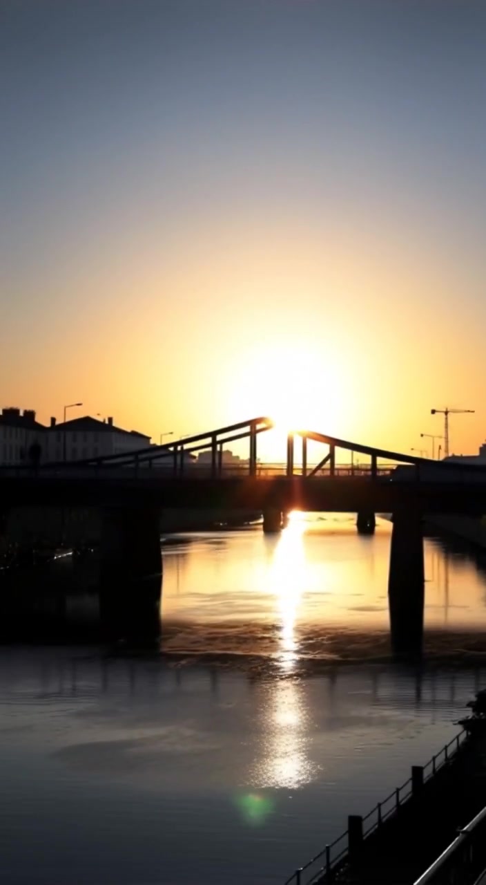 A gentle breeze ripples the water as a boat glides slowly beneath the serene pontoon bridge.