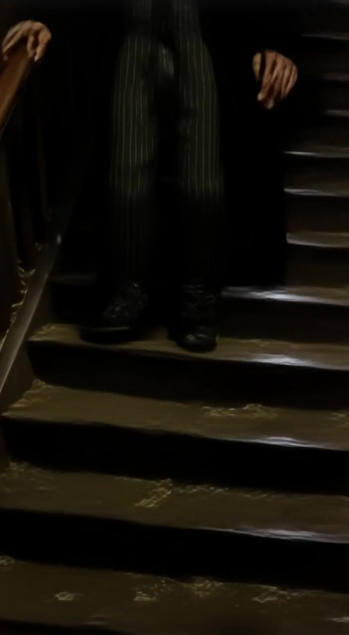 The boy ascends a dim staircase, dust motes swirling in the soft light, shadows flickering around him.
