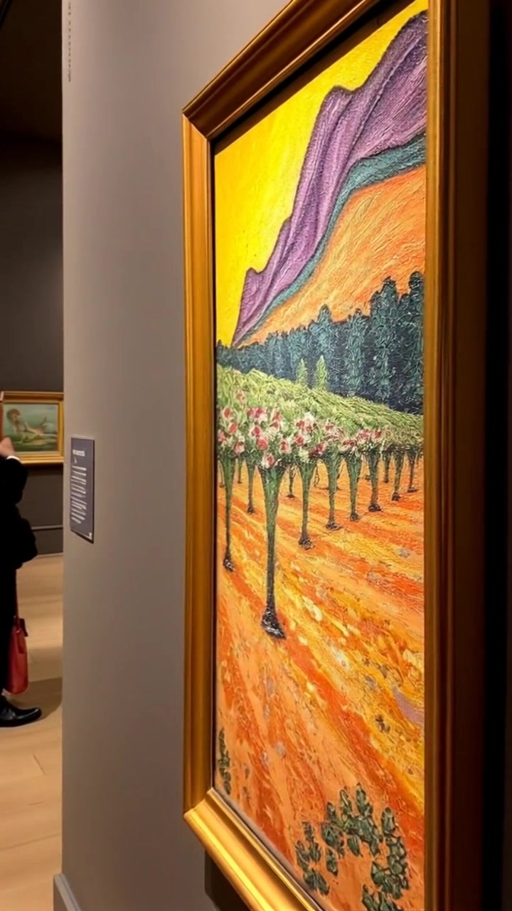 Scene: A close-up of 'The Red Vineyard' painting displayed elegantly in an art gallery, surrounded by soft, muted colors of the gallery walls. Style: Ambient lighting highlights the vibrant reds and greens of the painting, creating a serene and contemplative atmosphere. Motion: The camera slowly zooms in, focusing on the brush strokes and texture of the canvas, allowing viewers to appreciate the intricate details of the artwork.