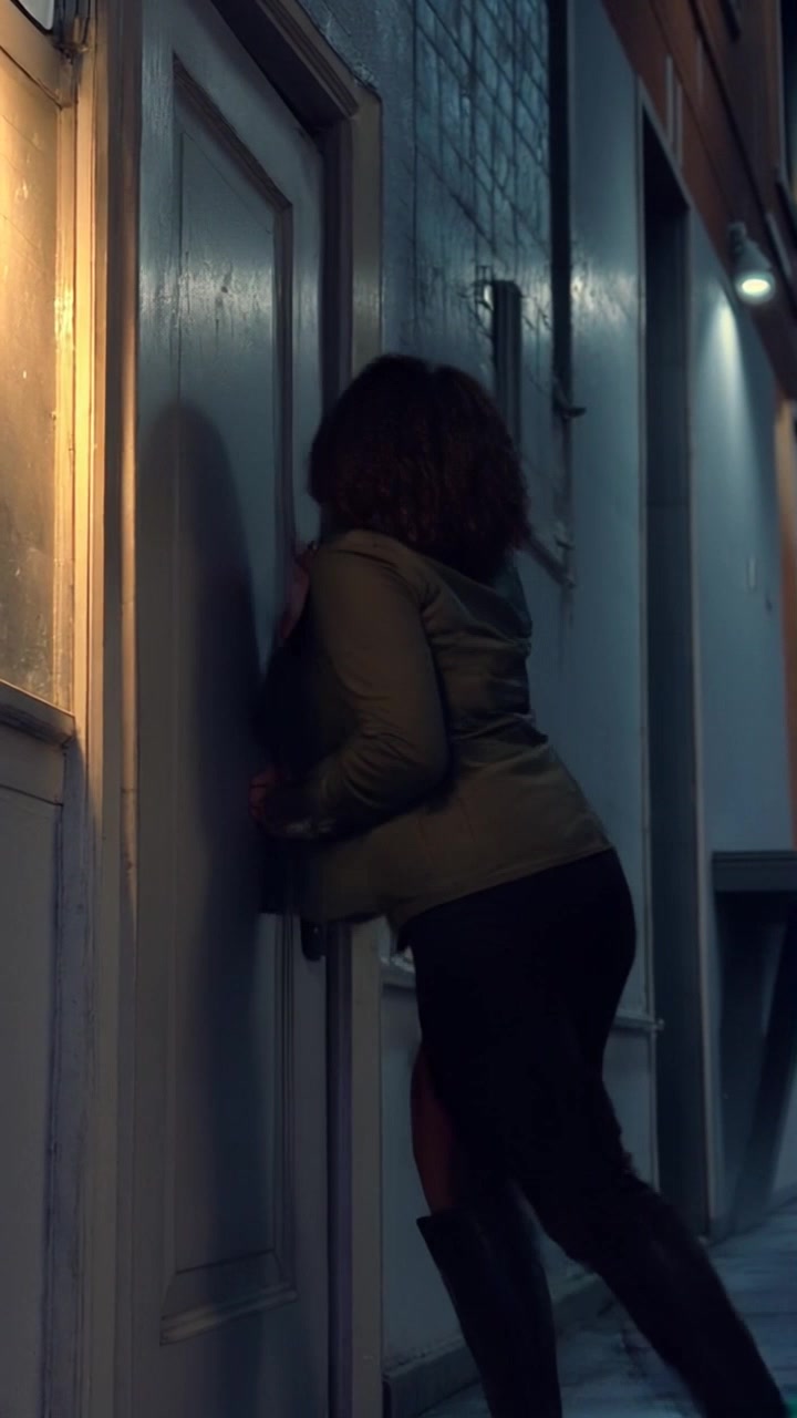 Subject: A young woman running into her bedroom with an anxious expression. Subject movement: She bursts through the door and slams it shut behind her, breathing heavily as she leans against it. Scene: A cozy yet slightly cluttered bedroom illuminated by soft afternoon light filtering through the curtains. Motion: The camera tracks her rapid entrance, capturing her tense movements in a handheld style to enhance the sense of urgency, before tilting up to emphasize the room and the weight of her emotional state.