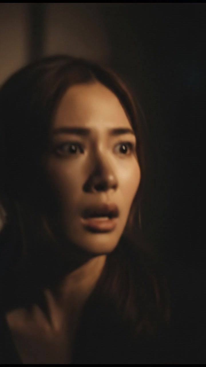 A close-up of Mei's panicked expression, realizing the presence behind her.