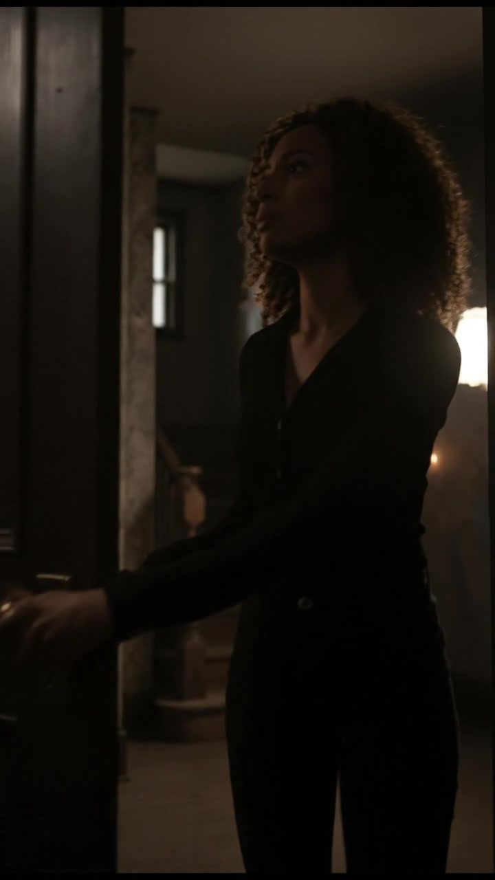 Nia standing at a locked door on the second floor, her hand resting on the doorknob.