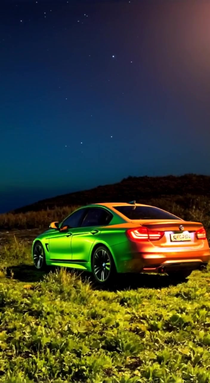 The car gently glimmers under the stars as a soft breeze rustles the grass around it.