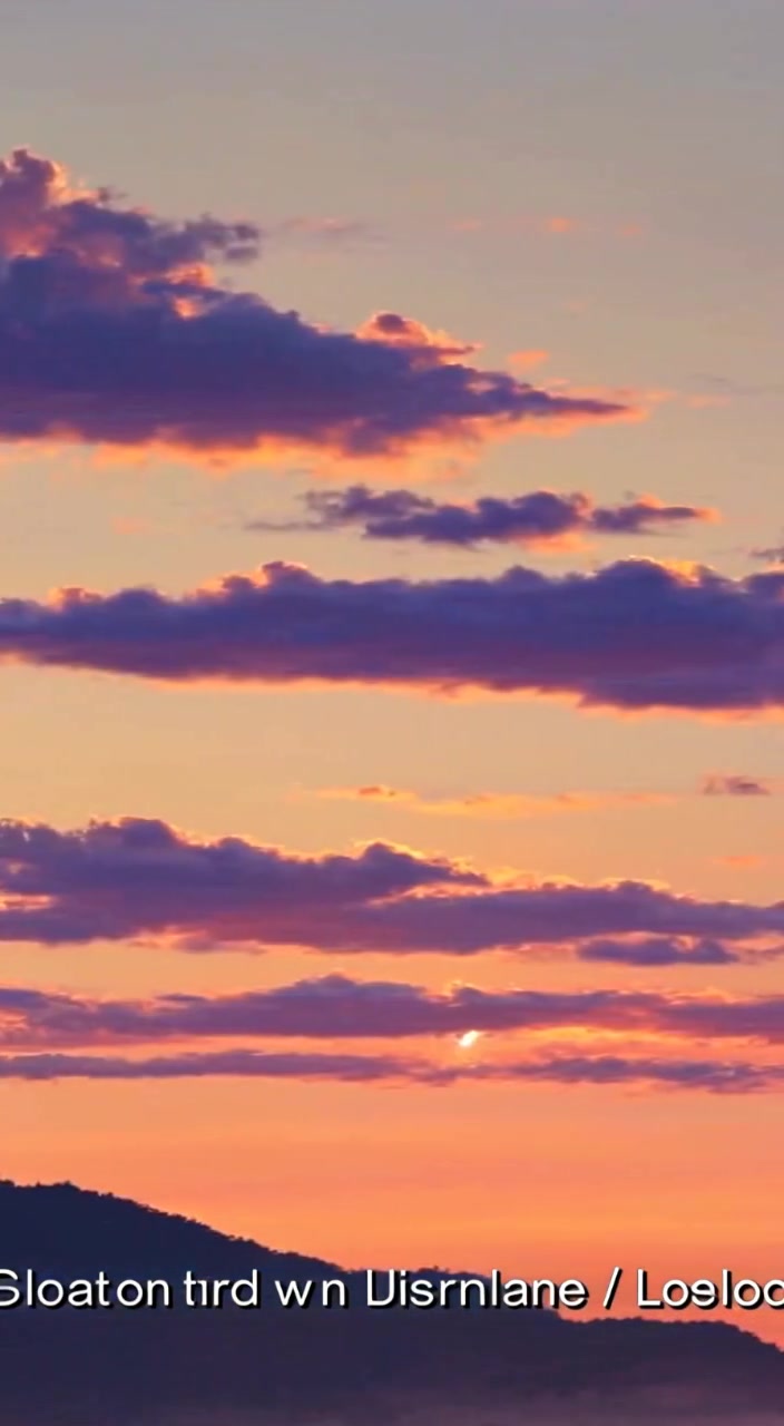 The man gazes towards the horizon, as the sun rises, casting a warm glow over the landscape.